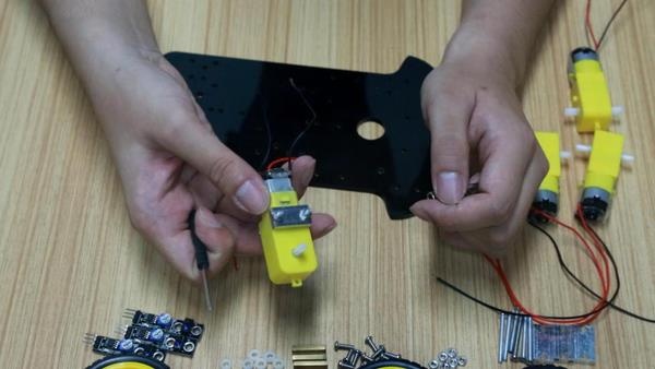 Passo 1.2: Fixação dos suportes acrílicos e parafusos de sustentação dos quatro motores DC no chassi inferior